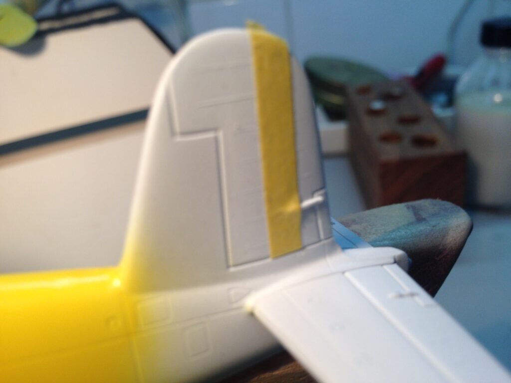 Processo de mascaramento das faixas de invasão pretas e amarelas na fuselagem do F4U-7 Corsair Italeri 1/72.
