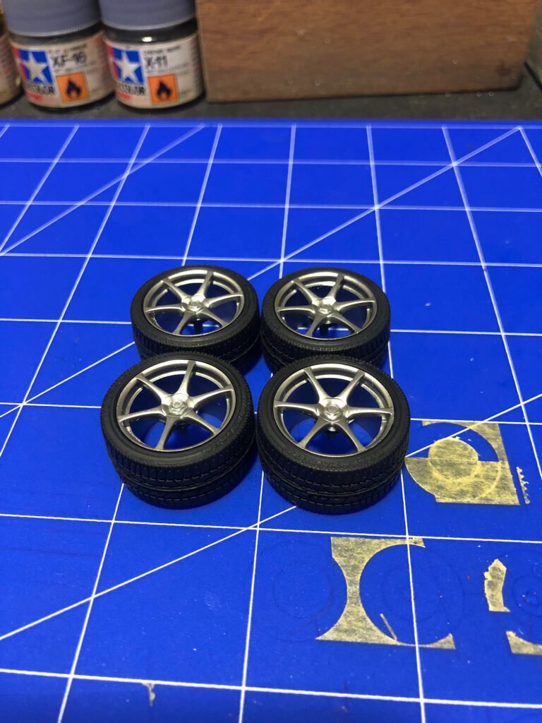 Rodas Interior do carro em miniatura do Nissan Skyline GT-R Tamiya 1/24 mostrando painel com decalques e bancos esportivos.