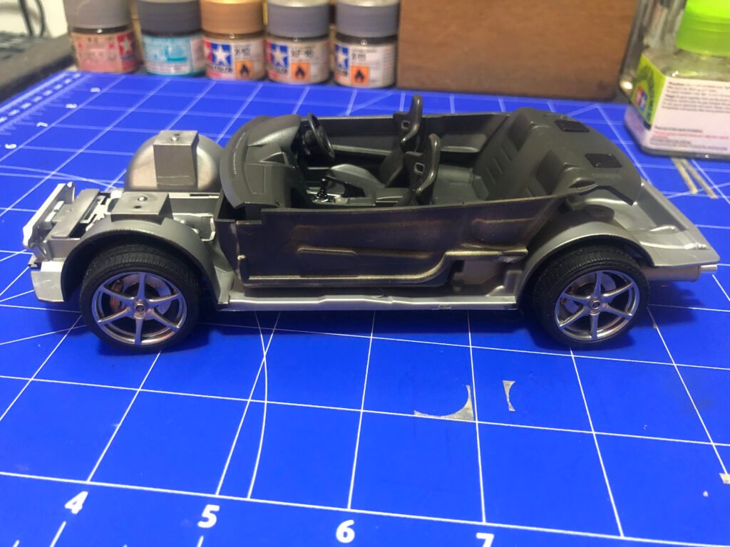 Interior do carro em miniatura do Nissan Skyline GT-R Tamiya 1/24 mostrando painel com decalques e bancos esportivos. lateral