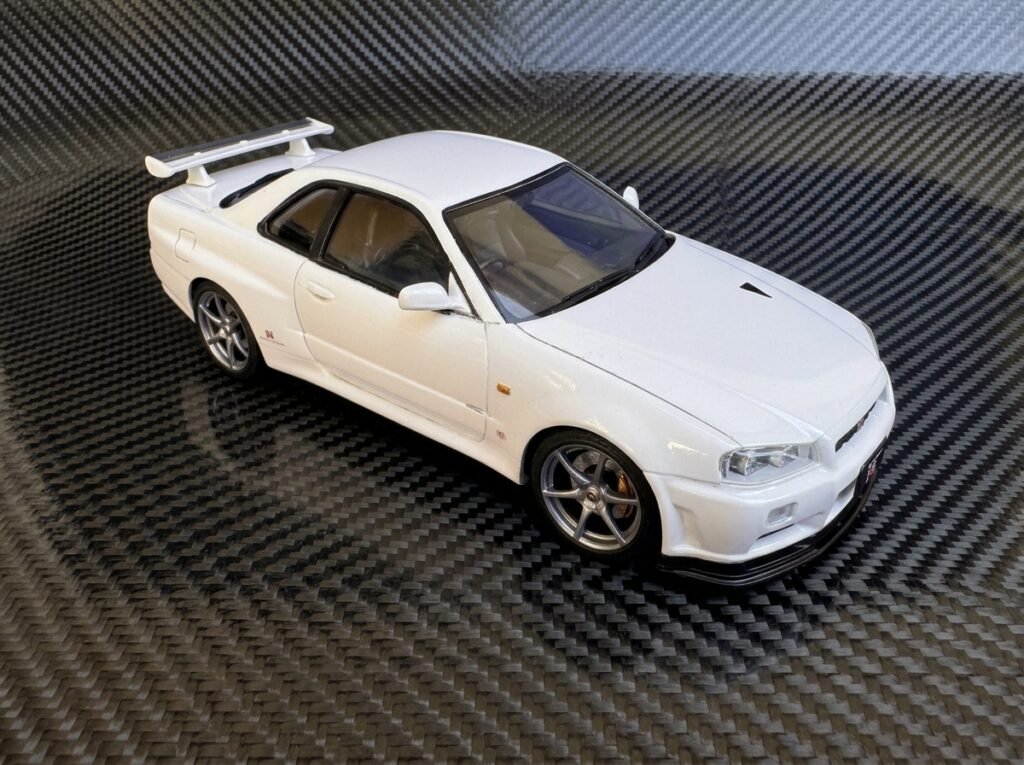 Modelo finalizado do Nissan Skyline GT-R Tamiya 1/24 V-Spec II em ângulo diagonal exibindo o brilho da carroceria.